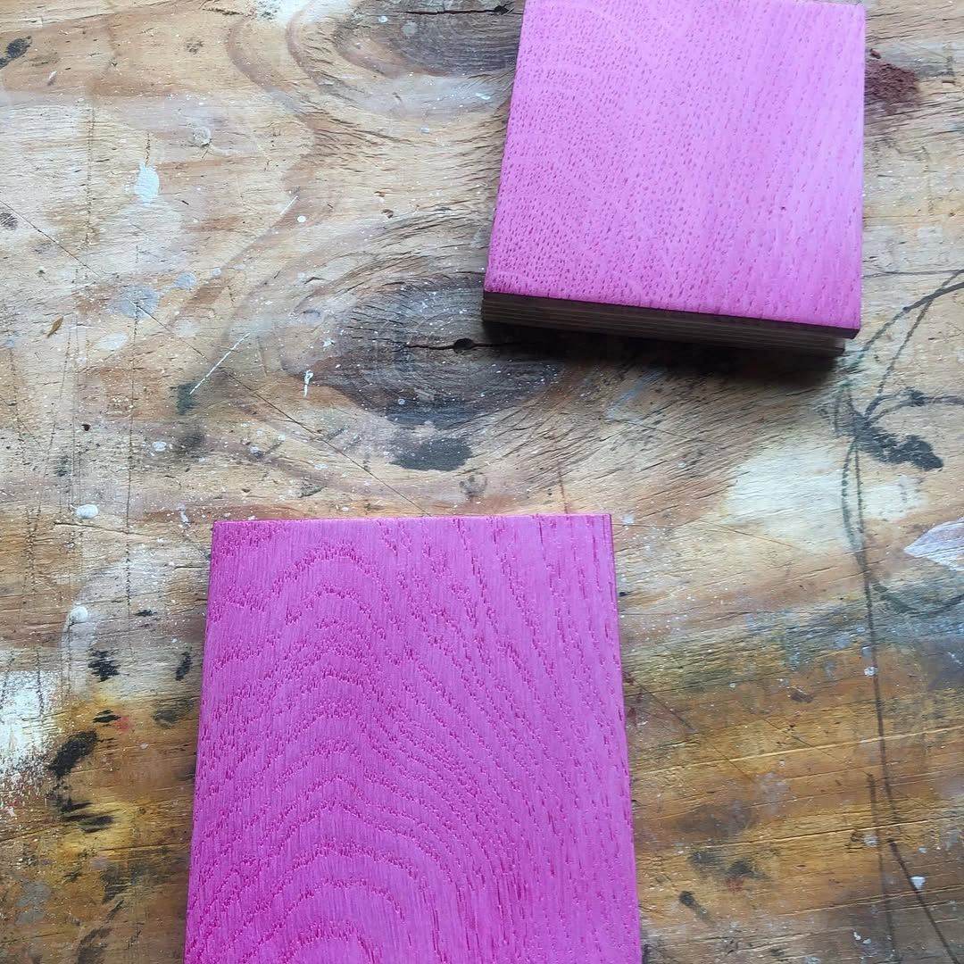 Two Pink Squares of Wood Are Sitting on a Wooden Table — Timberfection Queensland in Yatala, QLD
