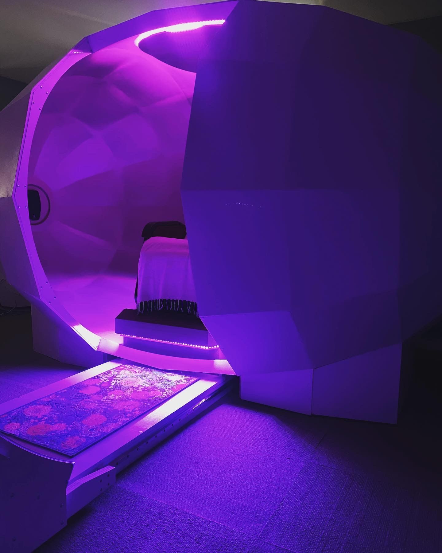 A room with purple lights and a bed in it