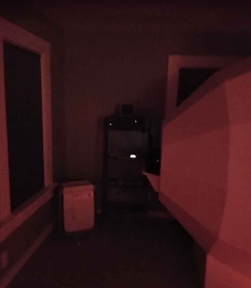 A dark room with a red light shining through the windows.