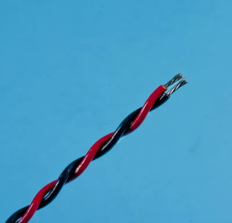 A pair of twisted red and black electrical wires with the insulation stripped at the ends, set against a blue background.
