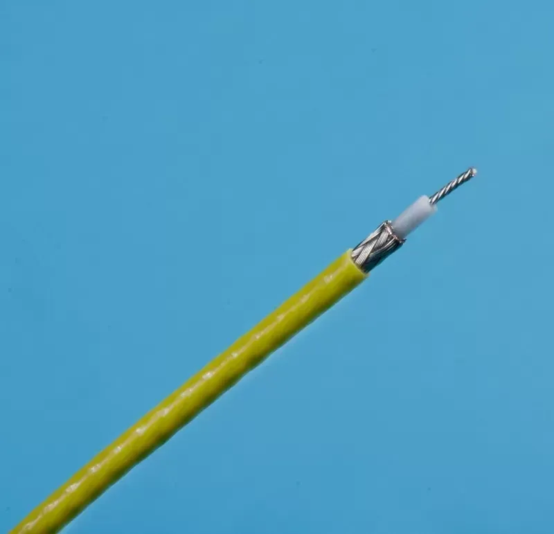 A stripped yellow coaxial cable showing its inner metallic braiding, white dielectric insulation, and central wire.