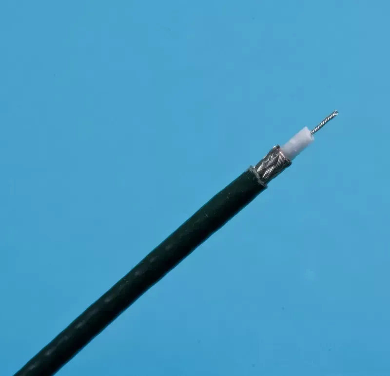 A section of coaxial cable against a blue background, showing the inner copper wire, white insulation, and metal shielding.