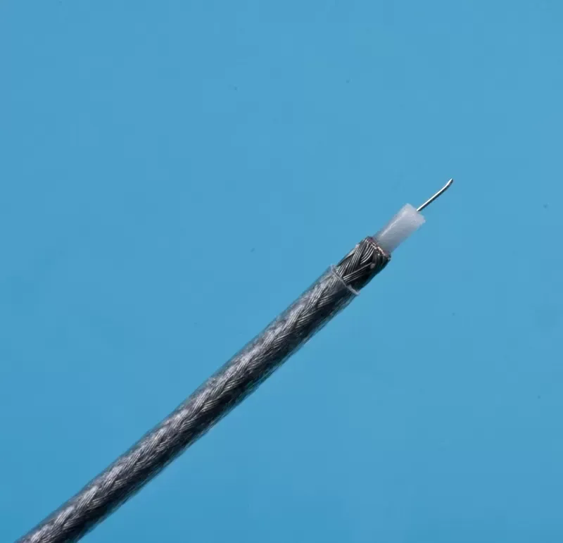 A coaxial cable end, showing the central wire, white insulation, and braided metal shielding against a blue background.