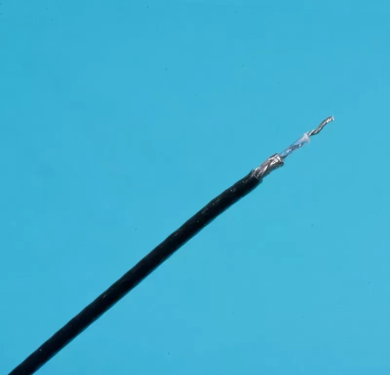 A close-up of a black insulated electrical wire with a stripped, twisted copper end against a bright blue background.