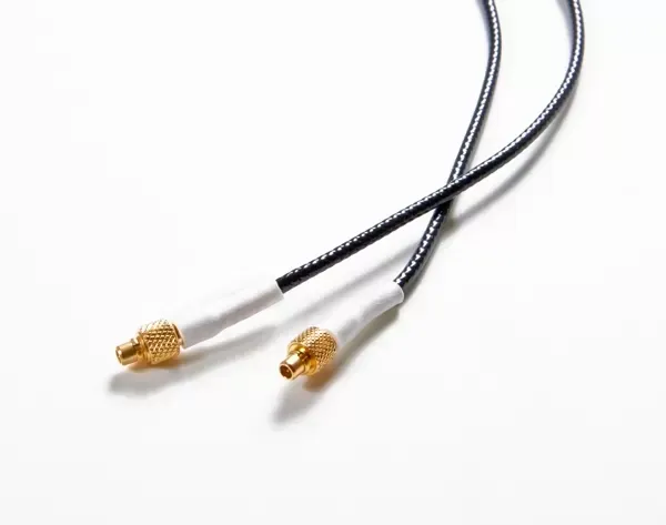 A black coaxial cable with two gold-colored SMA male connectors at the ends against a white background.