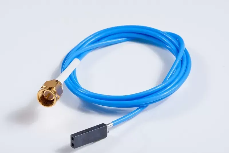 A blue cable with a gold SMA connector at one end and a black two-pin female jumper connector at the other.
