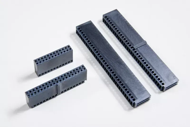 Four gray, rectangular dual-row female electronic headers of varying lengths arranged on a white surface.