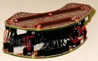 Two curved, red printed circuit boards connected by multiple black and white headers and red wire bundles.