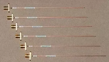 Six coaxial RF probes of varying lengths, each featuring a metallic SMA connector, laid out in descending order.