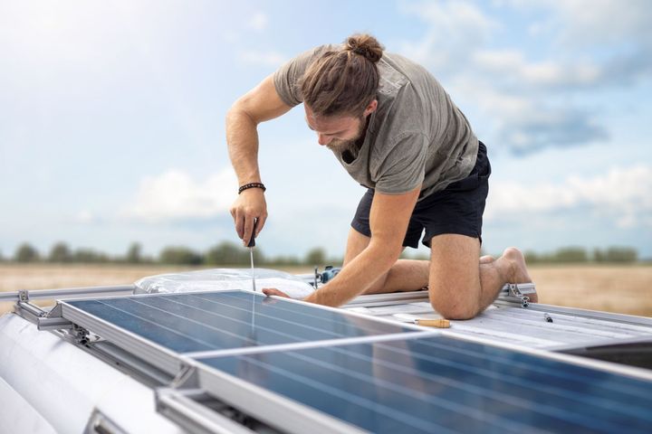 a man is installing solar panels on the roof of a van