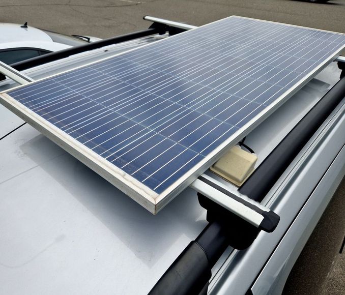 a solar panel is sitting on top of a silver car