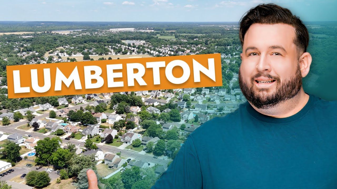 A man is standing in front of an aerial view of lumberton.
