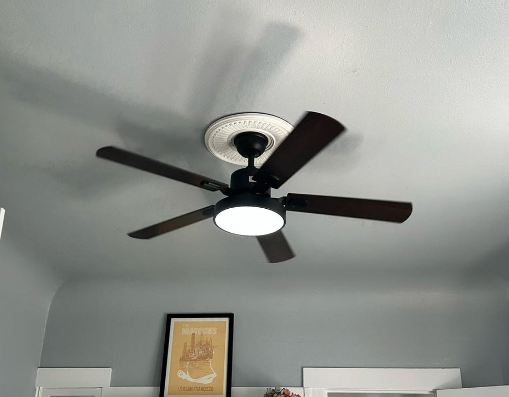 A ceiling fan is hanging from the ceiling of a room.