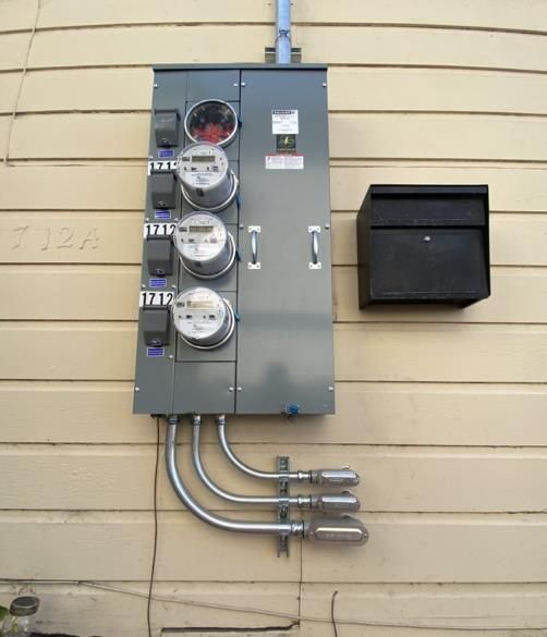 An electrical box on the side of a building with a mailbox next to it