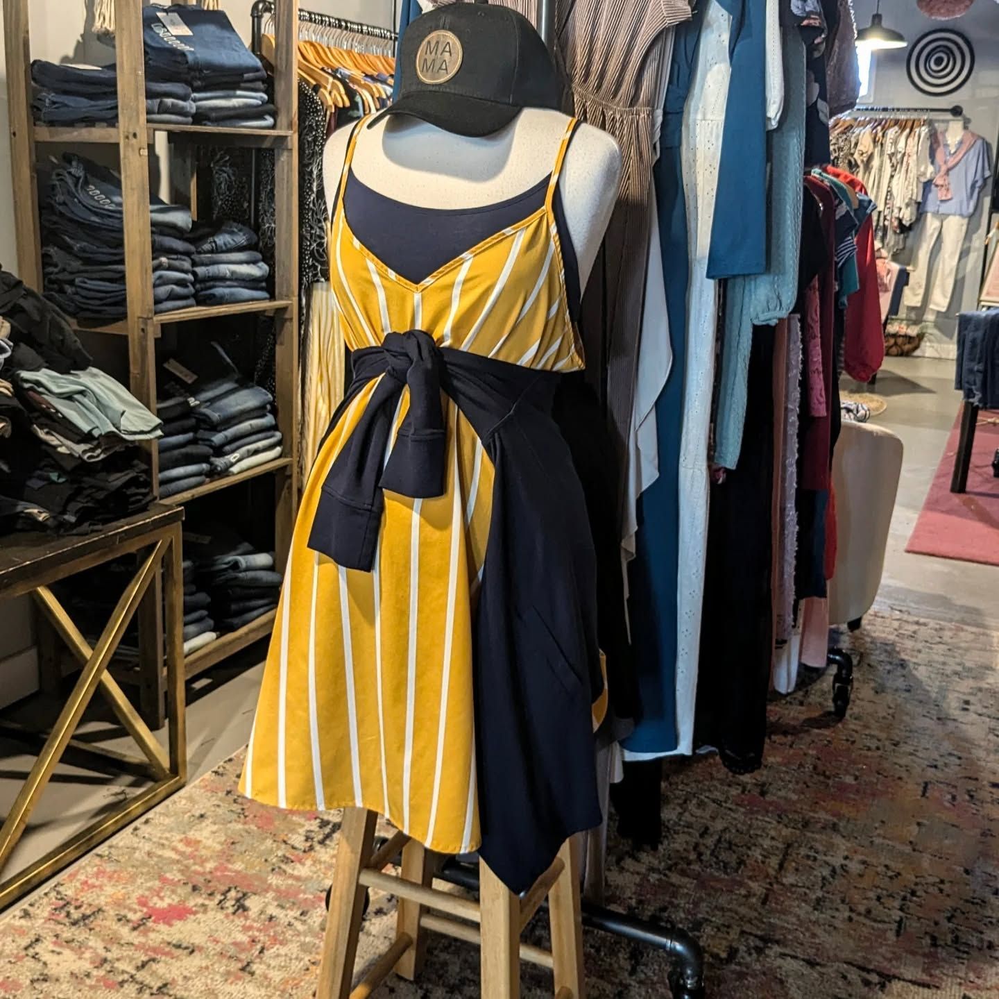 A yellow and black striped dress is on a mannequin in a store