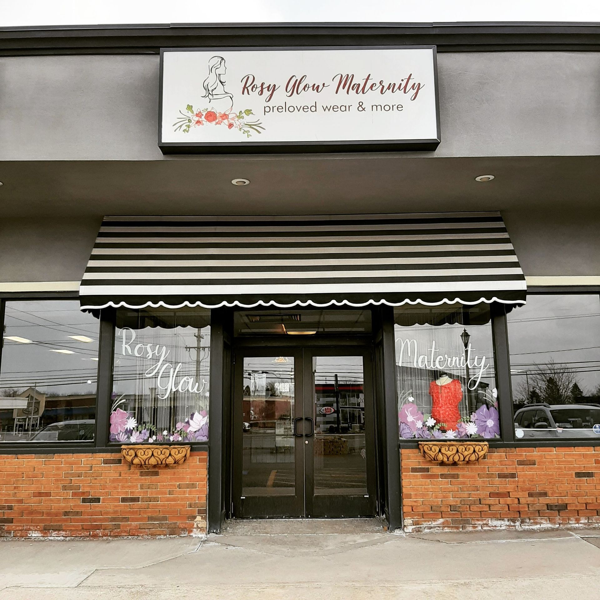 A store front with a sign that says rosy glow maternity