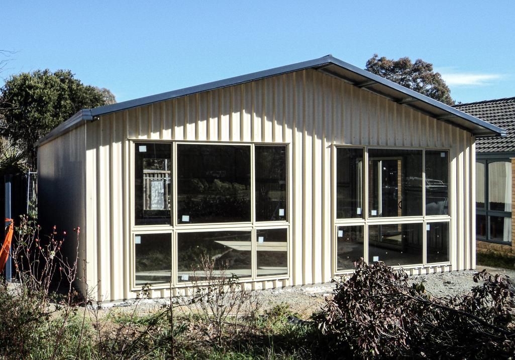 A House with A Lot of Windows and A Blue Sky in The Background — Clearspan Builders In Queanbeyan East, NSW