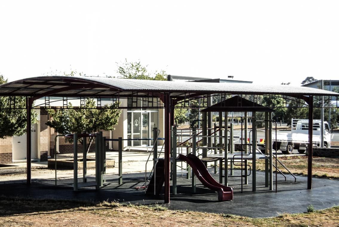 A Playground with A Slide Under a Canopy in A Park — Clearspan Builders In Queanbeyan East, NSW