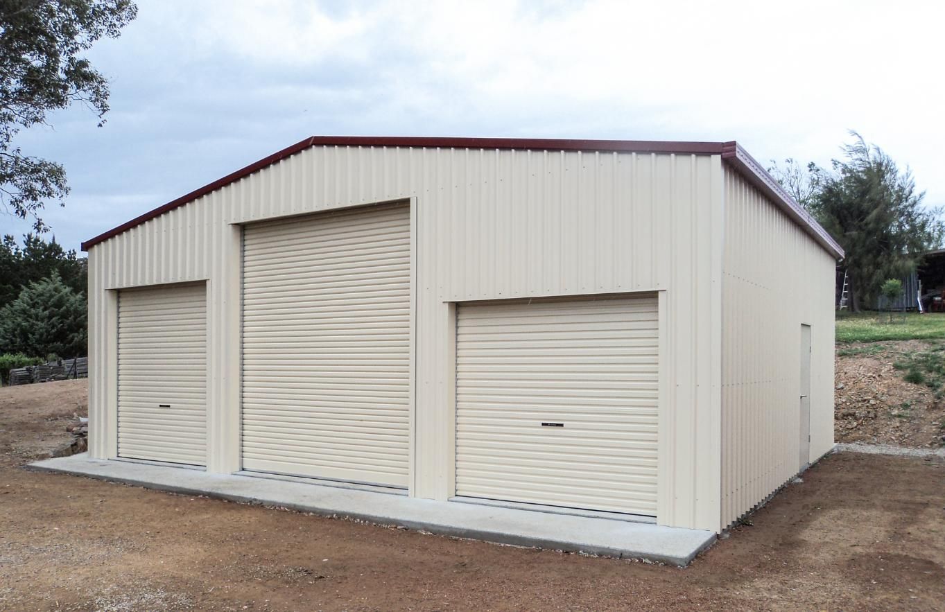 A White Garage with Three Garage Doors and A Red Roof — Clearspan Builders In Queanbeyan East, NSW