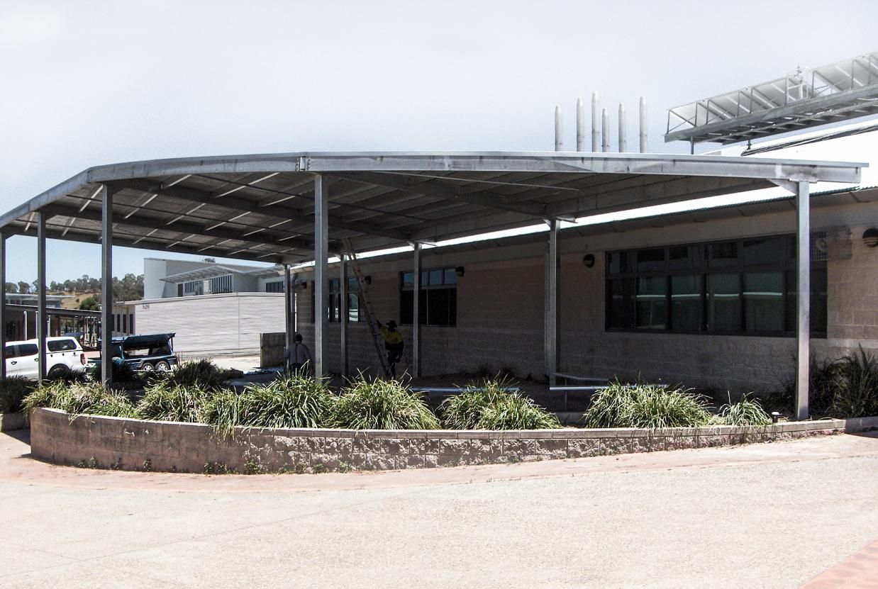 A Large Building with A Covered Area in Front of It — Clearspan Builders In Queanbeyan East, NSW