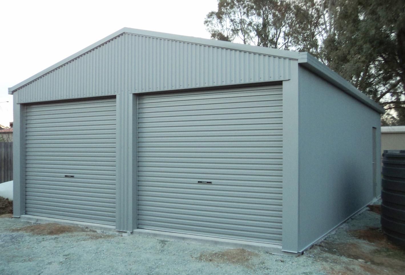 A Garage with Two Garage Doors and A Roof — Clearspan Builders In Queanbeyan East, NSW