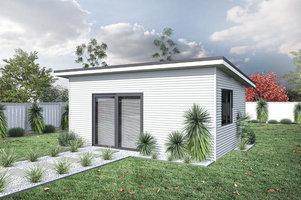 A Small White House Is Sitting in The Middle of A Lush Green Yard — Clearspan Builders In Queanbeyan East, NSW