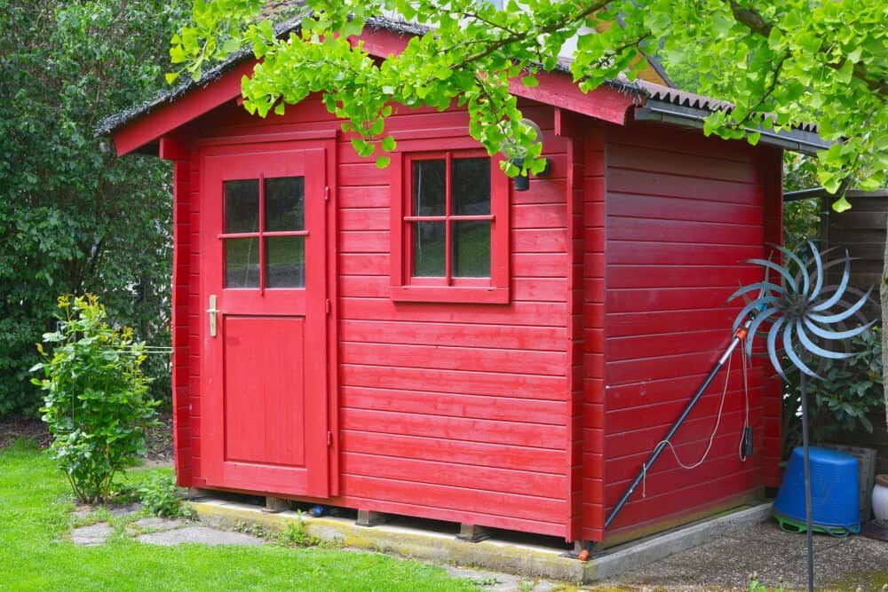 Red Wooden Garden Shed With Door, Window, and Decorative Metal Whirligig — Clearspan Builders In Braidwood, NSW