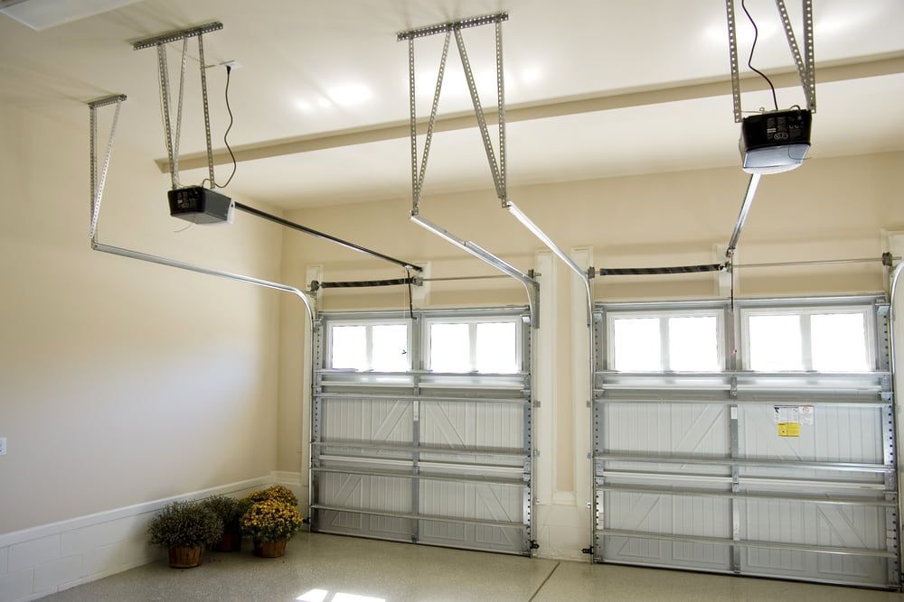 Garage Interior With Two White Garage Doors, Each With an Electric Opener — Clearspan Builders In Yass, NSW