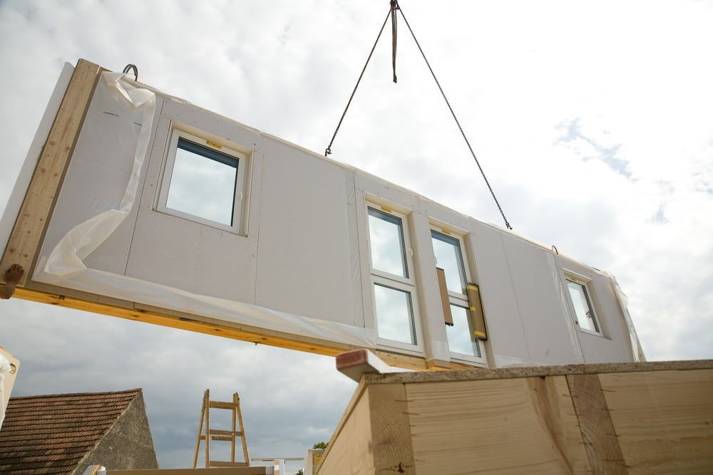 Crane Lifting a Prefabricated Wall Panel With Windows, Placing It on a Building Frame — Clearspan Builders In Royalla, NSW