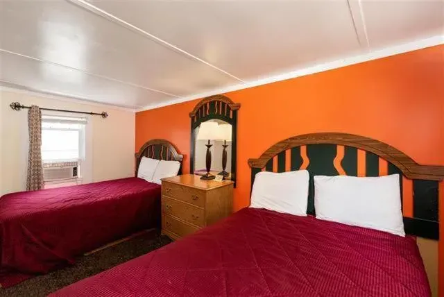 A hotel room with two beds and a mirror