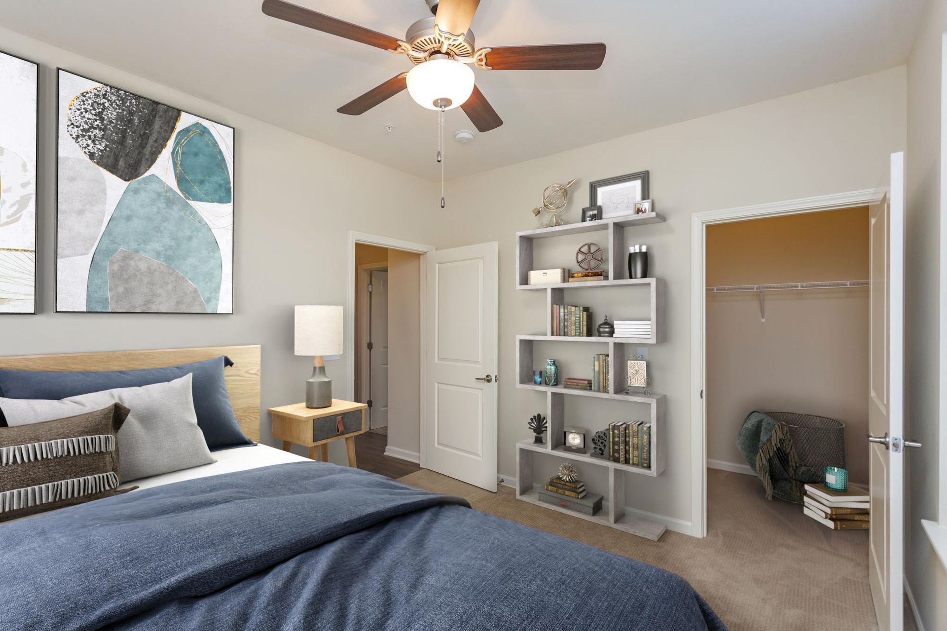 A bedroom with a bed featuring a blue comforter, a wood headboard, a ceiling fan, a bookshelf, and an open walk-in closet.