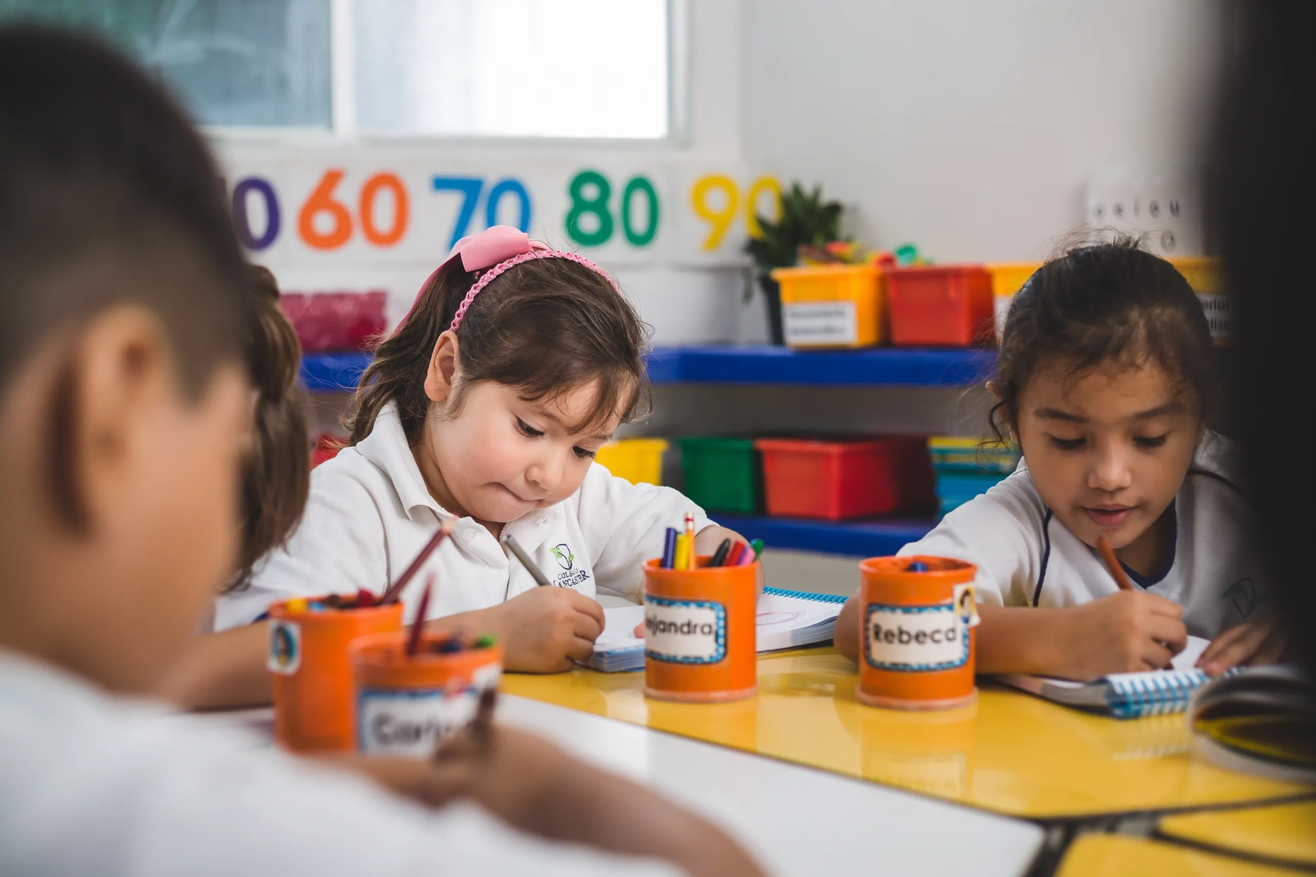 Niño trabajando en un experimento científico con un microscopio. El fondo incluye una pizarra y una figura diagonal azul.