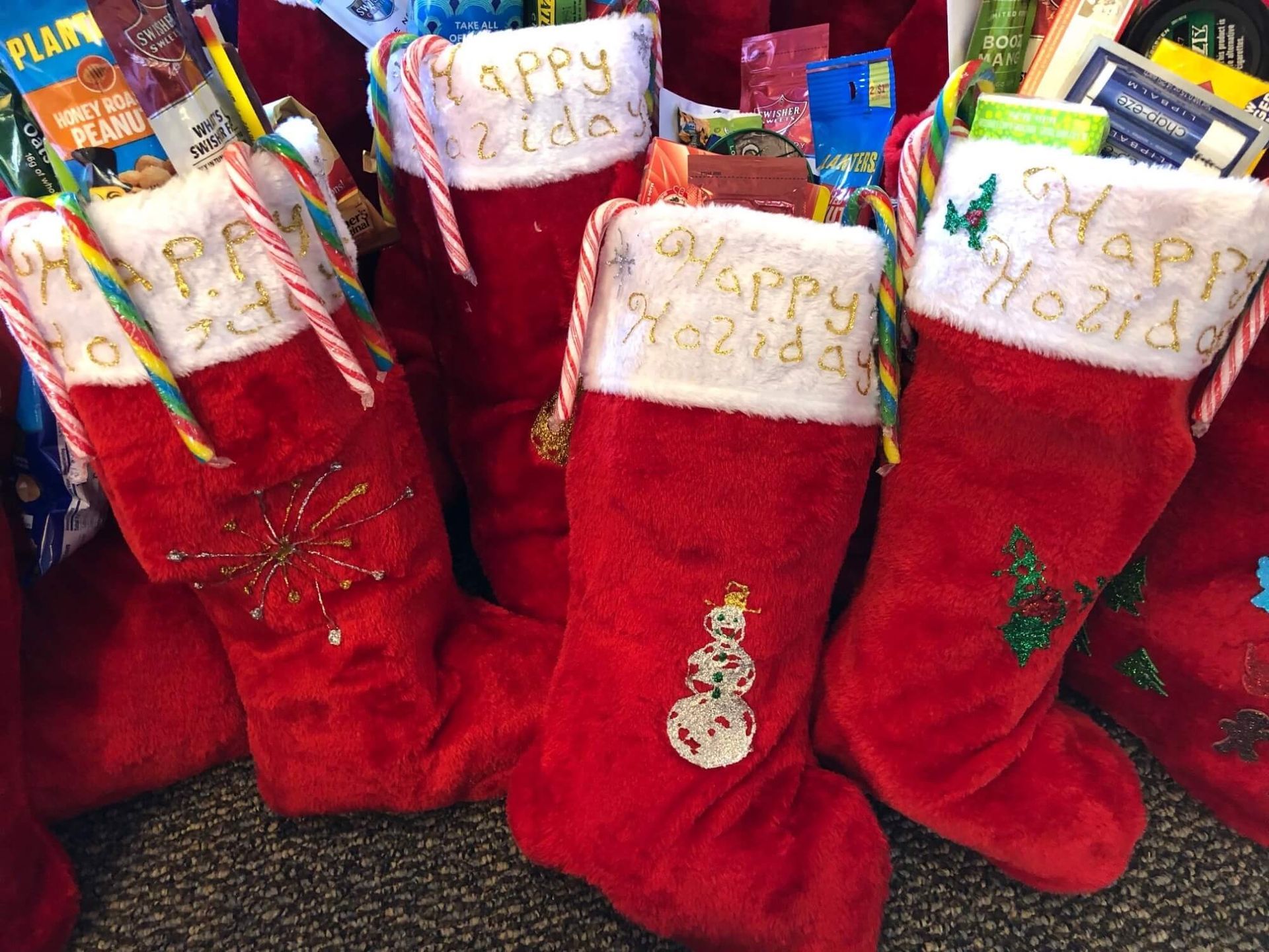 a group of red christmas stockings filled with candy canes and gifts .