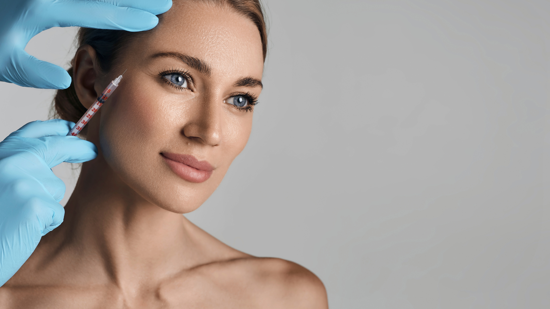 A woman is getting a botox injection in her face.