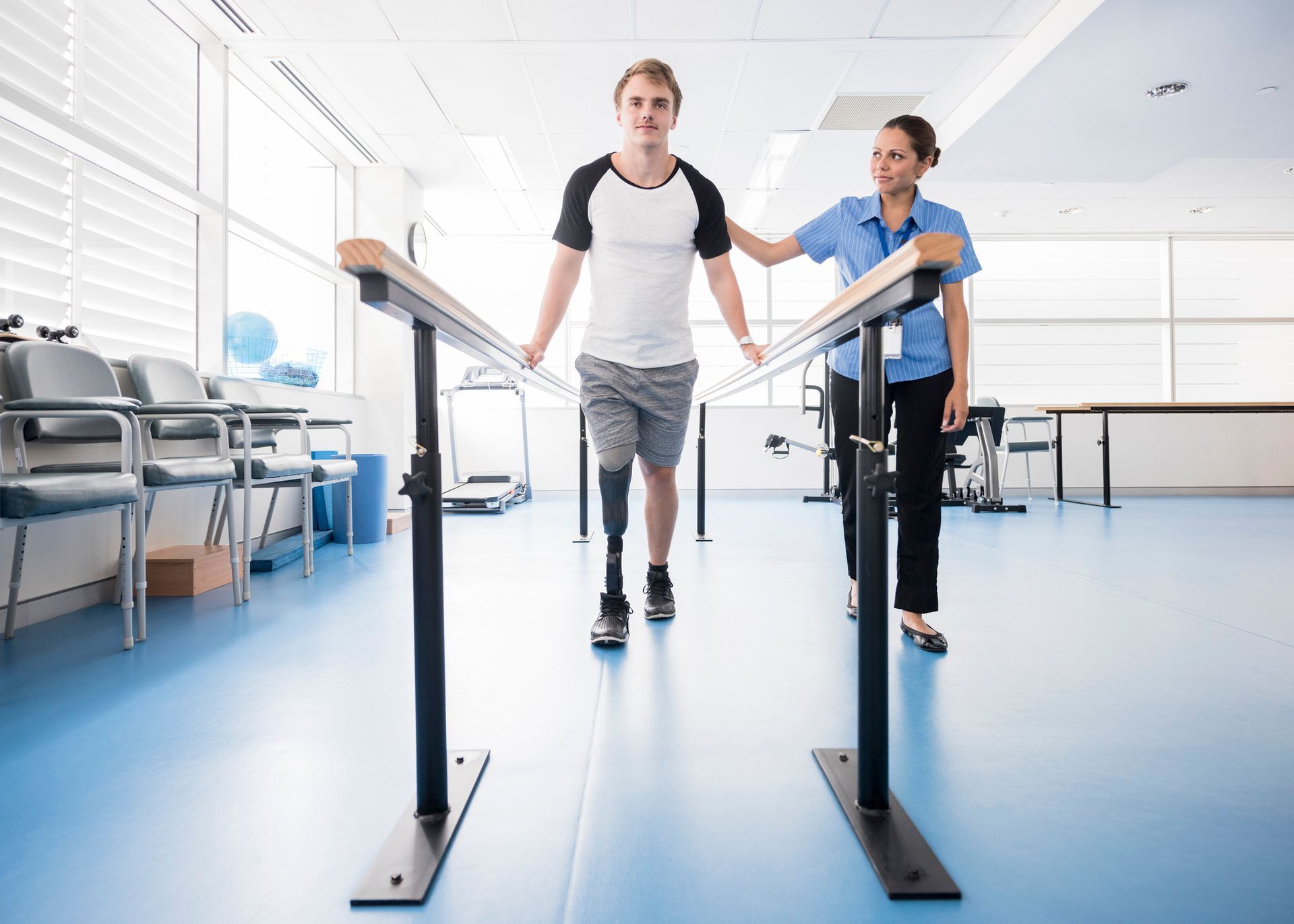 A man with a prosthetic leg is walking on parallel bars — Wetherill Park, NSW — JQ Physiotherapy & Sports Rehabilitation