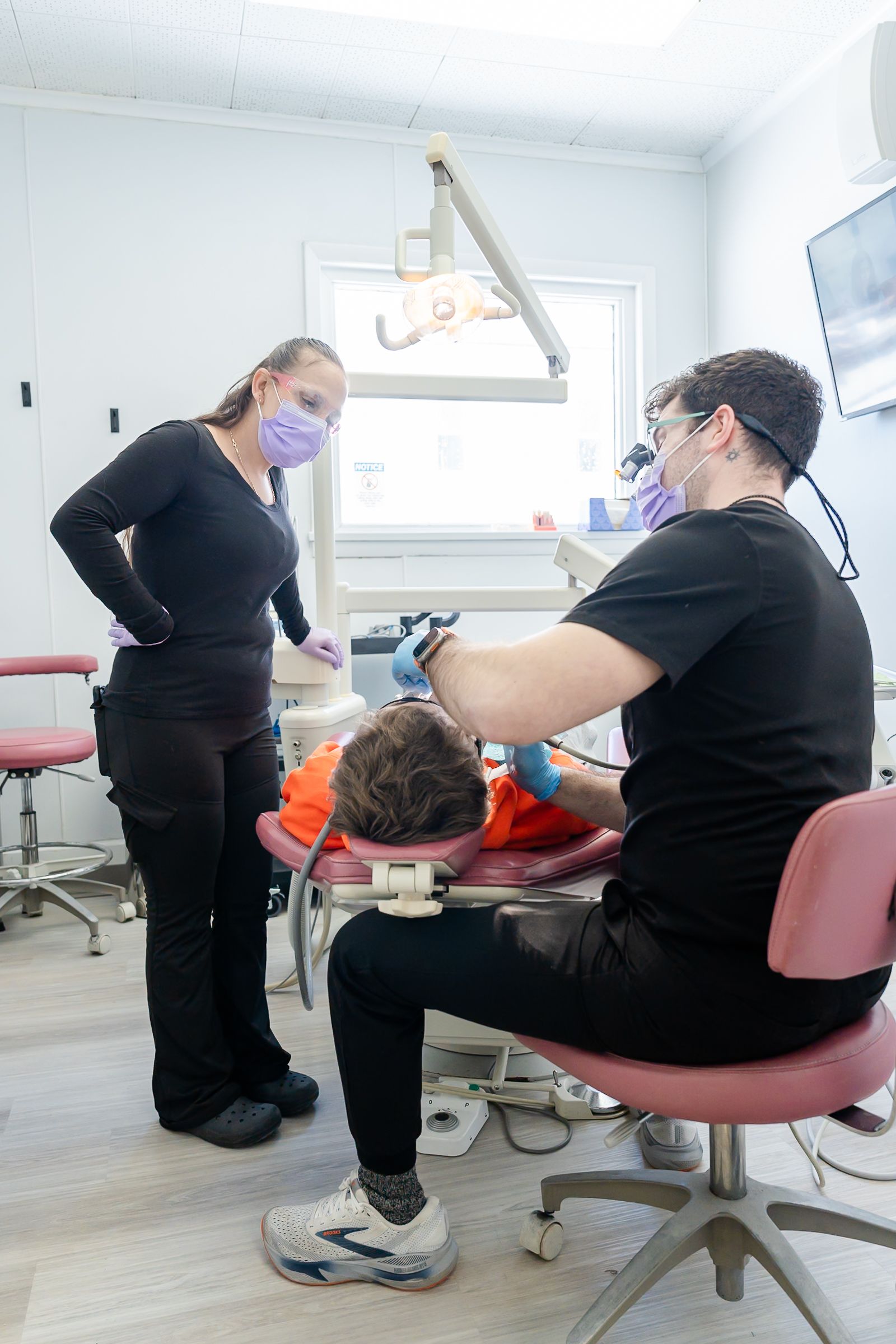 Dentist and assistant working on a patient in a dental office.