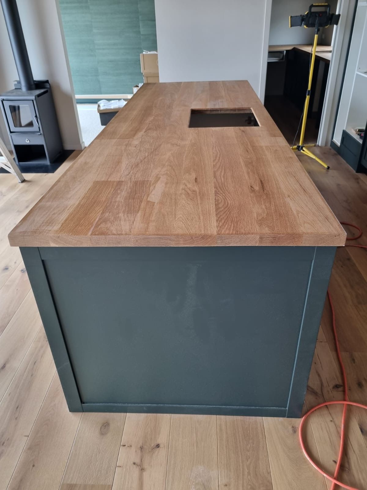 A kitchen island with a wooden counter top and a sink.
