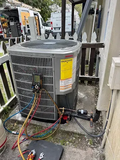 An air conditioner is being installed on the side of a house.
