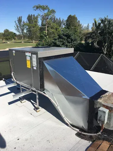 An air conditioner is sitting on top of a roof.