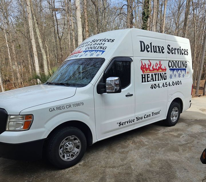 A white van that says deluxe services on it