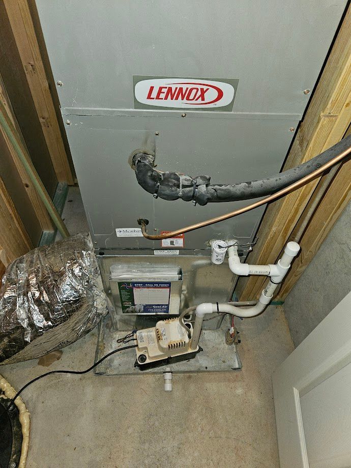 A lennox air conditioner is sitting in a basement next to a door.
