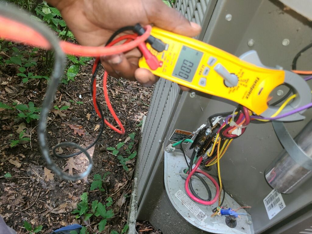 A person is using a clamp meter to measure voltage