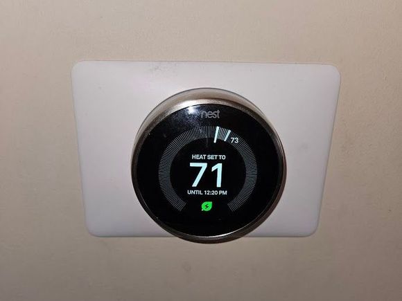 A nest thermostat is plugged into a wall.