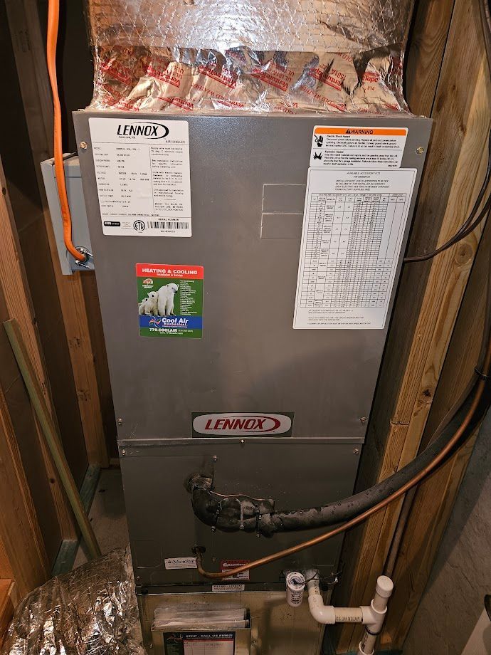 An air conditioner is sitting in the corner of a room in a house.