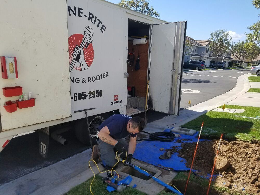Sewer Line Repair Orange, CA – technician repairing sewer line near service truck with equipment on residential street