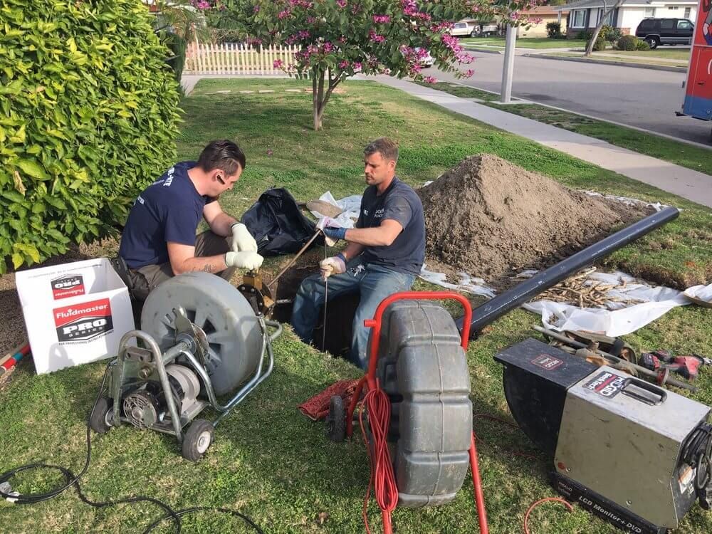 Top 5 Plumbing Maintenance Tips for Orange CA Homeowners – Plumbers using drain cleaning equipment outdoors.