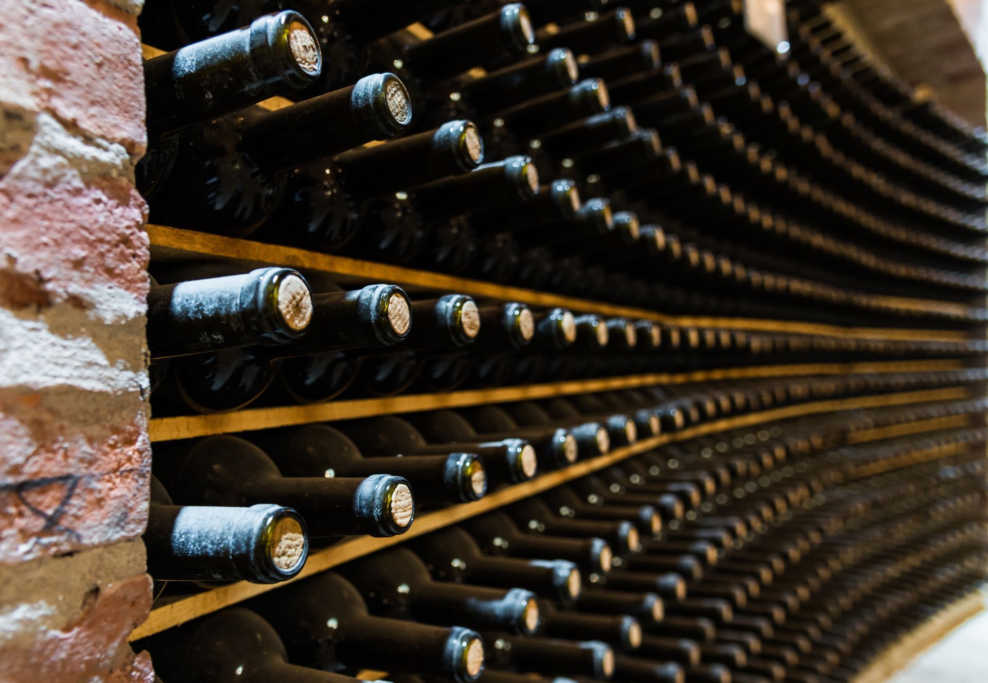 A row of wine bottles stacked on top of each other in a wine cellar.