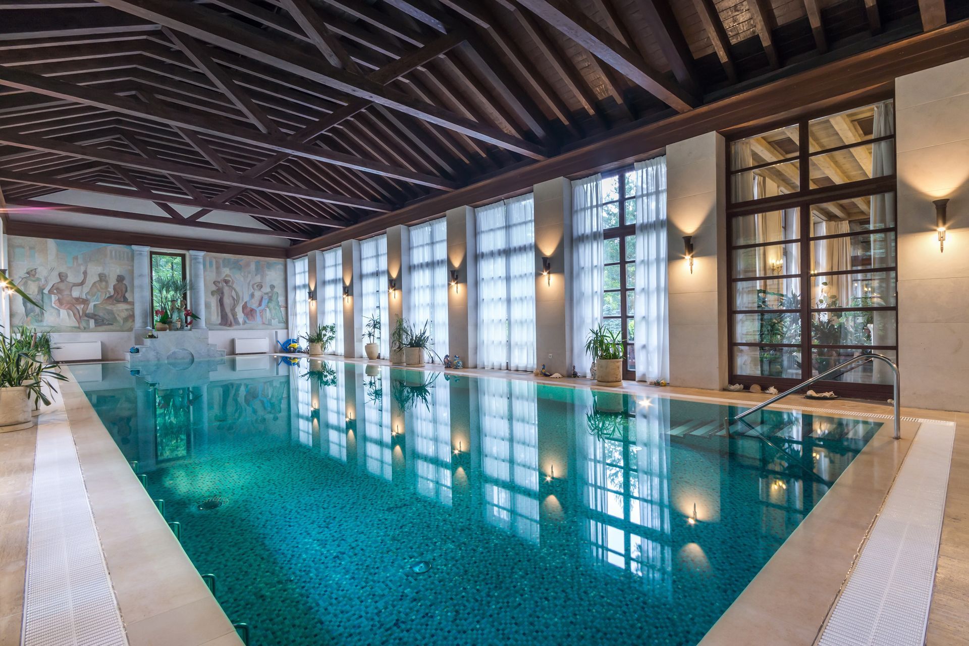 A large indoor swimming pool with a lot of windows