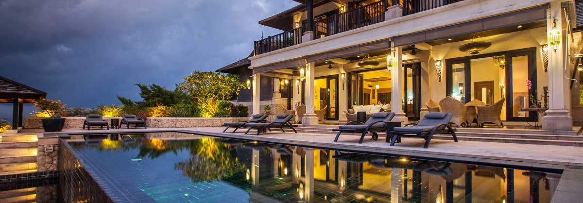 A large house with a swimming pool in front of it.