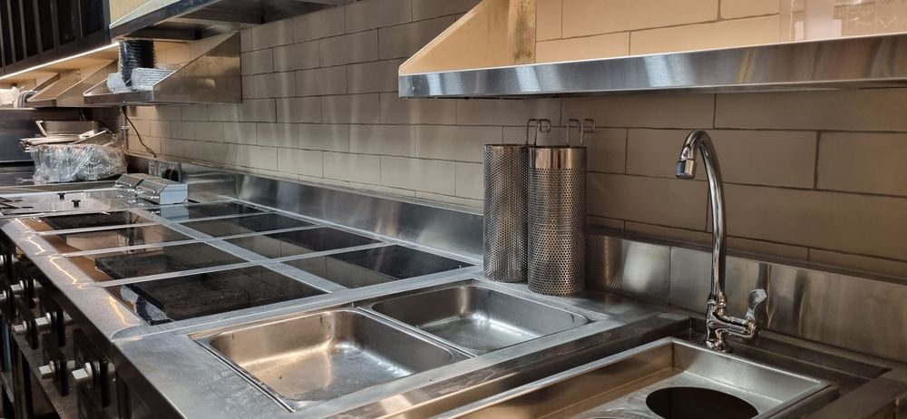Commercial kitchen workspace with stainless steel surfaces, sinks, and equipment — Central Coast Commercial Kitchen Cleaning in Swansea, NSW